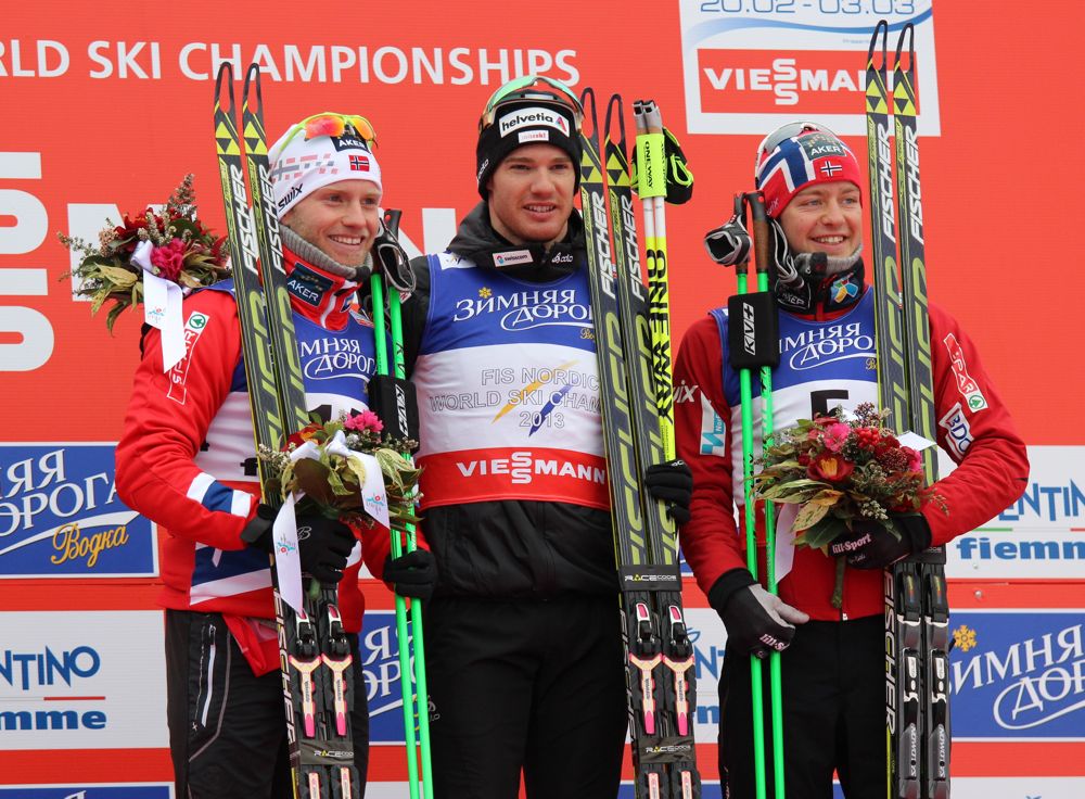 Swiss winner Dario Cologna (c) with Norwegians Martin Sundby (l) in second and Sjur Røthe in third on the 30 k skiathlon podium at the 2013 World Championships in Val di Fiemme, Italy.