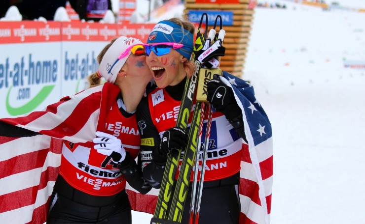 Jessie Diggins kisses teammate Kikkan Randall as the two celebrate their history-making gold medal in the team sprint at World Championships on Sunday.
