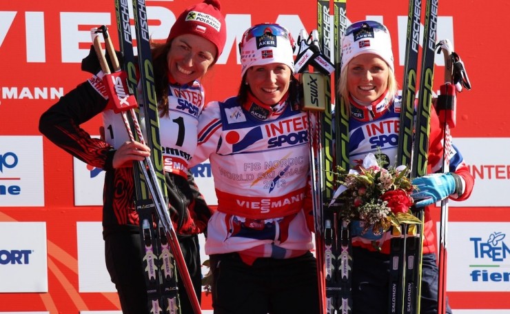 Podium after the women's 30 k classic: Bjørgen smiles after besting Justyna Kowalczyk and Therese Johaug.