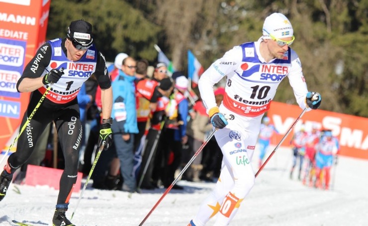 Sweden's Johan Olsson (r) leads Dario Cologna of Switzerland early in Sunday's 50 k classic mass start at the 2013 World Championships in Val di Fiemme, Italy. Cologna crashed on a downhill around 21 k, and Olsson skied away for the win.