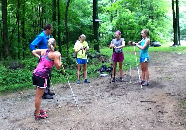 Several women with the Stratton Mountain School T2 Team check in with head coach Gus Kaeding during a bounding-interval session on Tuesday in Stratton, Vt.