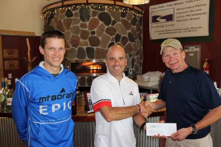 Mt. Borah Owner Chris Jackson (center) hands over the $6,500 donation to CAMBA Executive Director Ron Bergin (far right) at the River's Eatery in Cable, WI.  The event, run by Race Director Jack Zabrowski (pictured far left), raised enough funds to create about a mile of new single track for the expanding CAMBA trail system.