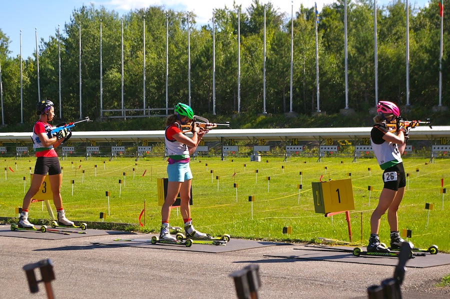 US Biathlon teammates Hannah Dreissigacker (r) and Susan Dunklee (c) in the range together with Biathlon Canada's Rosanna Crawford on the final standing of Sunday's 10 k pursuit at North American Biathlon Rollerski Championships in Jericho, Vt.
