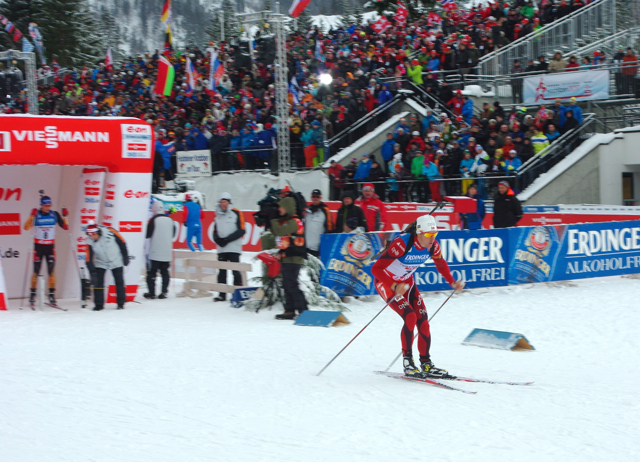 Norway's Lars Berger heads out of the start box as Simon Schempp of Germany looks on. In bibs seven and eight, the two capitalized on their early start positions and the shifting weather: Berger won, and Schempp placed eighth.