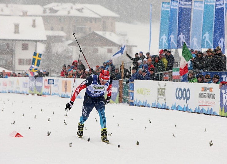 Sergey Ustiugov (RUS) lunges across the finish line in the men's 15 k classic in the 2014 U23 World Championships in Val di Fiemme, Italy. Ustiugov finished second after winning Wednesday's freestyle sprint. (Photo: Fiemme 2014)