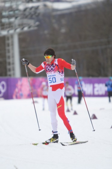 Canada's Alex Harvey stops for a moment to tell head coach Justin Wadsworth (not shown) that his skis aren't gliding. Harvey completed the second lap, but did not finish the 15 k classic individual start at the 2014 Olympics in Sochi, Russia.