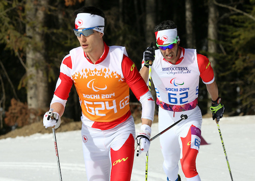 Graham Nishikawa pacing Brian McKeever to his eighth Paralympic gold on Monday in the 20 k visually impaired classic race in Sochi, Russia. McKeever used both Nishikawa and Erik Carleton as guides, switching halfway through the distance race. (Photo Scott Grant/Canadian Paralympic Committee)