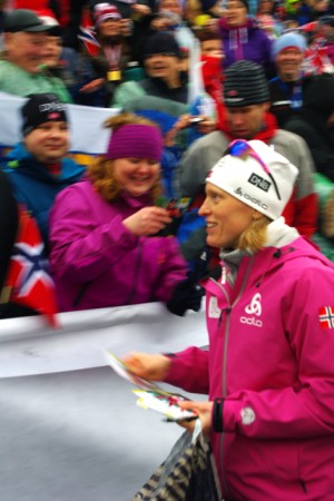 Tora Berger (NOR) hands out autograph cards to fans at the Holmenkollen stadium after finishing second in the 10 k pursuit.