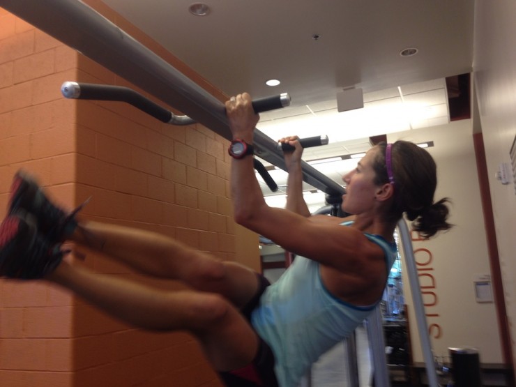 Chelsea Holmes working on core with a leg raise and twist from the pull-up bar