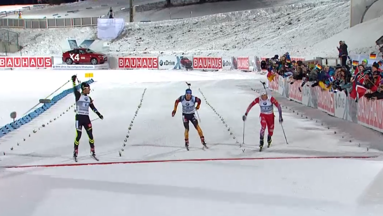Martin Fourcade of France (left) celebrates his team's comeback win in the mixed relay in Östersund, Sweden today. Norway (right, Lars Helge Birkeland) finished second and Germany (center, Simon Schempp) third.