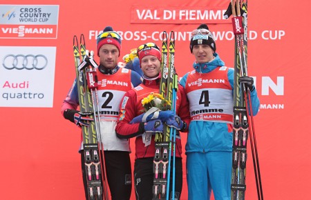 The men's 2015 Tour de Ski overall podium following Sunday's 9 k freestyle pursuit: with winner Martin Johnsrud Sundby (c) of Norway, runner-up Petter Northug (l) of Norway, and Russia's Evgeniy Belov in third. (Photo: Val di Fiemme/www.fiemmeworldcup.com)