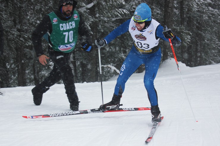 Coach Erik Flora runs to grab a new pole for Rosie Brennan, APU, 3rd after she broke her pole and was given an oversized one. Women's 10 k freestyle, 2015 Cross Country Championships, Houghton, Michigan