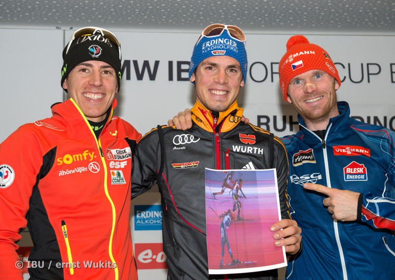 Mass start winner Simon Schempp (GER) hold up a printout of the photo finish, flanked by second place Quentin Fillon-Maillet (FRA, left), who lost by just eight centimeters, and third-place Michal Slesingr (CZE). (Photo: IBU/Ernst Wurz)