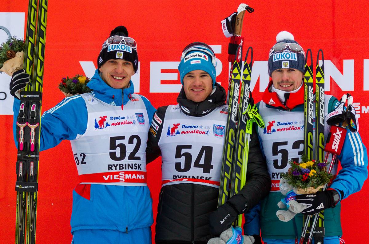 Men's 15 k podium, from l-r Evgeniy Belov of Russia, second, Dario Cologna of Switzerland, first, and Sergey Ustiugov of Russia, third