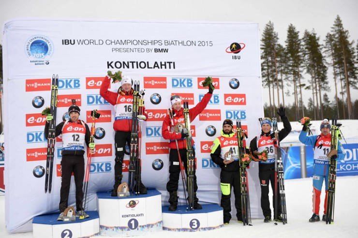 The men's 10 k sprint podium at 2015 IBU World Championships in Kontiolahti, Finland. From left to right: Silver medalist Nathan Smith (Canada), gold medalist Johannes Thingnes Bø (Norway), bronze medalist Tarjei Bø (Norway), Simon Fourcade (France) in fourth, Erik Lesser (Germany) in fifth, and Evgeniy Garanichev (Russia) in sixth. (Photo: Fischer/NordicFocus) 