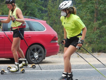 Methow Valley Nordic Team skiers Ella Hall and Claire Waichler rollerski amidst the smoke on closed Highway 20 this summer. (Photo: Leslie Hall)