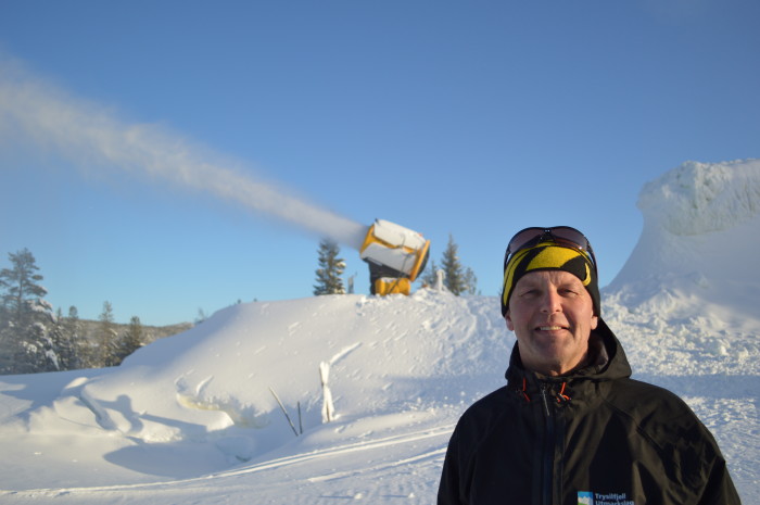 The head of Trysil's early season snow project, Ola Gerhard Sørhuus stands near a snowmaking machine and mound of snow in Trysil, Norway. (Photo: Ole Tangnes)