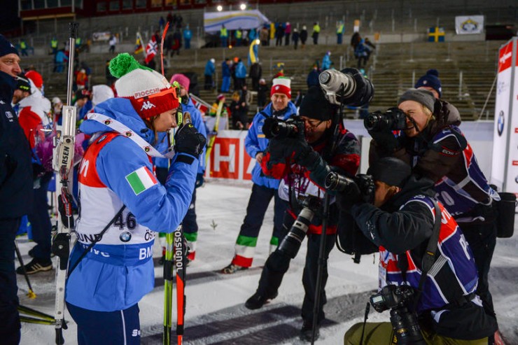 Italy's Dorothea Wierer (l) smiles for cameras after her first-career IBU World Cup win on Thursday in Ostersund, Sweden. She won the 15 k by 14 seconds. (Photo:  IBU/Evgeny Tumasov)