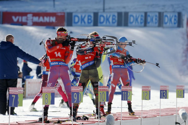 American Tim Burke (14) during one of his last two standing stages, while shooting alongside a German, Slovenian, and Russian. (Photo: IBU/Kvetoslav Frgal)