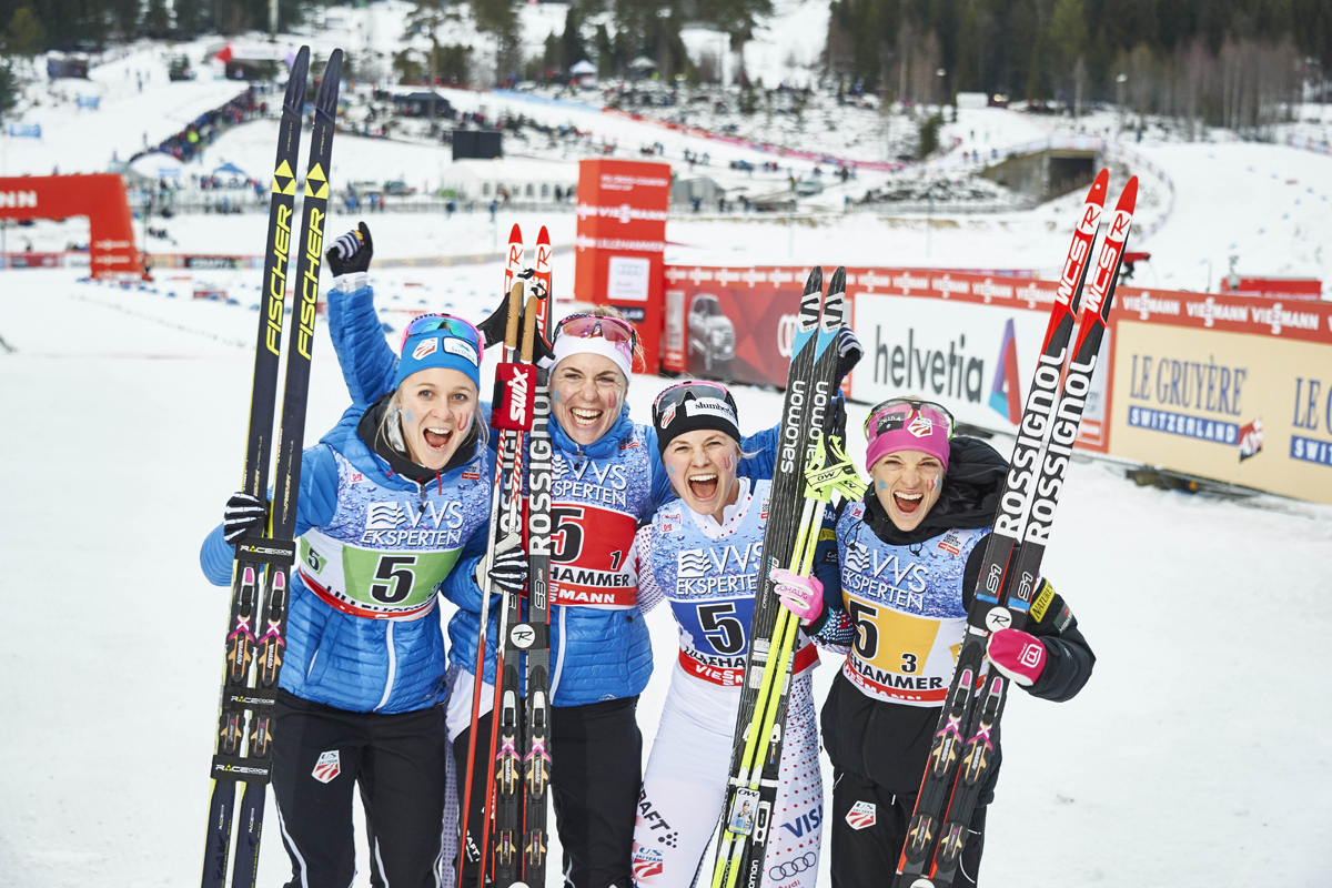 The U.S. women celebrate third place in Sunday's 4 x 5 k relay at the World Cup in Lillehammer, Norway. (From l to r) Sadie Bjornsen, Rosie Brennan, Jessie Diggins, and Liz Stephen. (Photo: Fischer/NordicFocus)