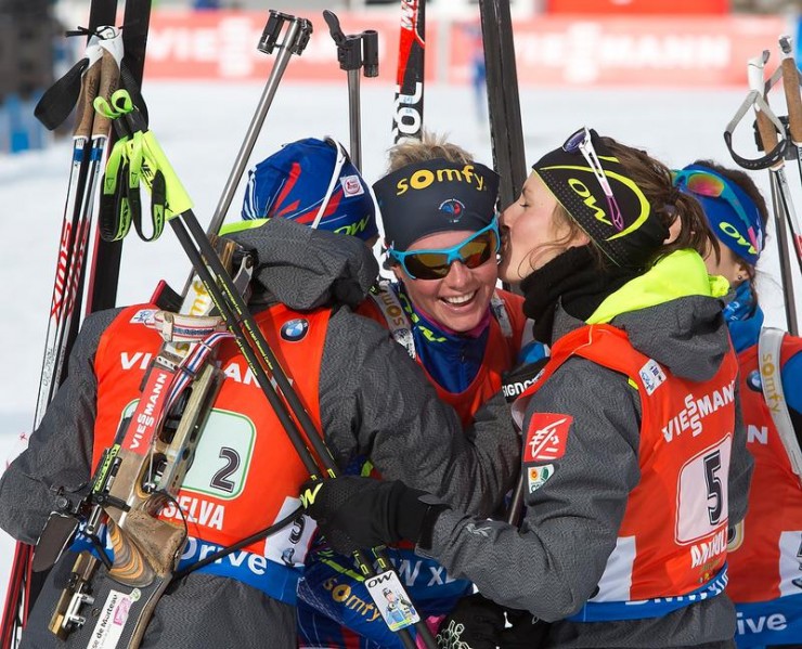 The French women's 4 x 6 k relay team, including Justine Braisaz, Anaïs Bescond and Anaïs Chevalier, hugs and kisses anchor Marie Dorin Habert at the finish, after Habert secured their IBU World Cup victory by 17 seconds over the Czech Republic on Sunday in Antholz, Italy. (Photo: IBU)