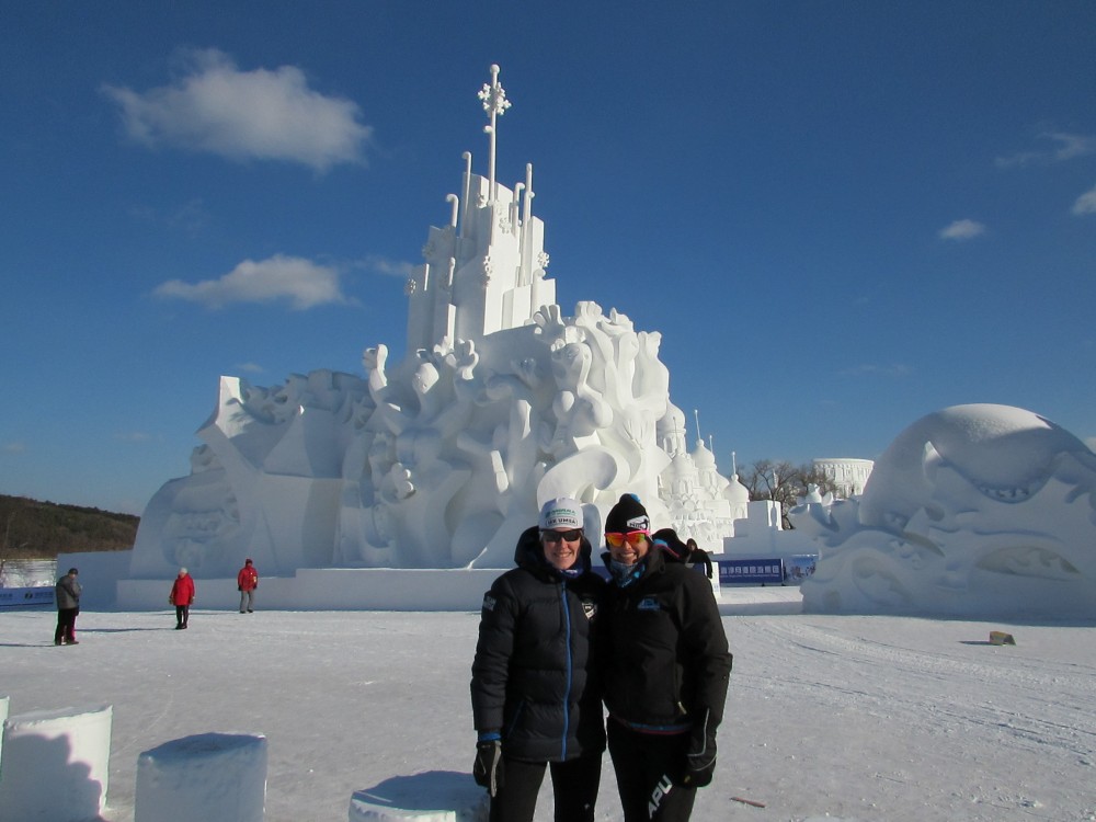 Swedish skier and former University of Vermont athlete, Linda Danvind-Malm (l) and American Lauren Fritz (APU) stand in front of one of the many snow castles that line the lap lane to the 50 k classic Vasaloppet marathon during the 2016 China Tour de Ski in Changchun. (Photo: Lauren Fritz)