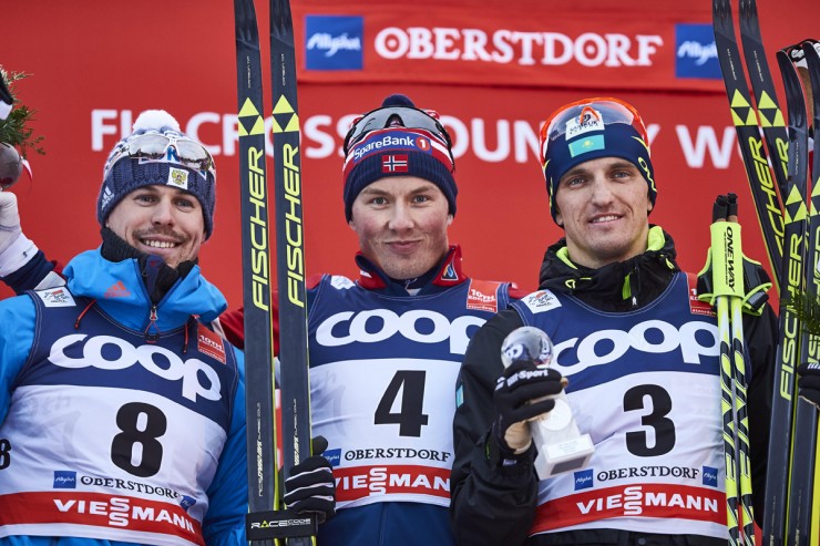 Norway's Emil Iversen (c) on the podium after winning his first World Cup at Stage 4 of the Tour de Ski in Oberstdorf, Germany. Russia's Sergey Ustiugov (l) placed second and Kazakhstan's Alexey Poltoranin (r) was third. (Photo: Fischer/NordicFocus)