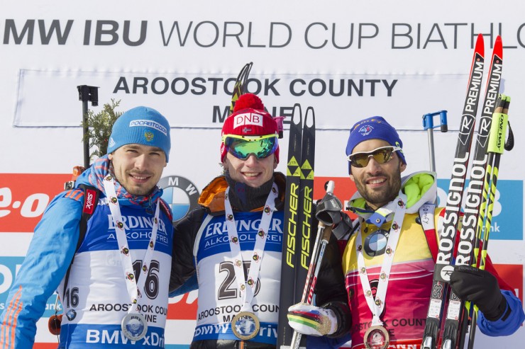 The men's sprint podium at the IBU World Cup in Presque Isle, Maine, with Norwegian winner Johannes Thingnes Bø (c), Russia's Anthon Shipulin (l) in second, and France's Martin Fourcade (r) in third. (Photo: Fischer/NordicFocus)