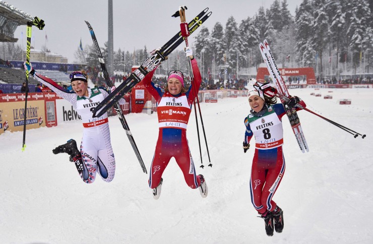 Jessie Diggins (l) of the U.S. Ski Team and two Norwegians Maiken Caspersen Falla (c) and Heidi Weng (r) jump for joy after reaching the podium in second, first and third, respectively, in the World Cup skate sprint in Lahti, Finland. (Photo: Fischer/NordicFocus)