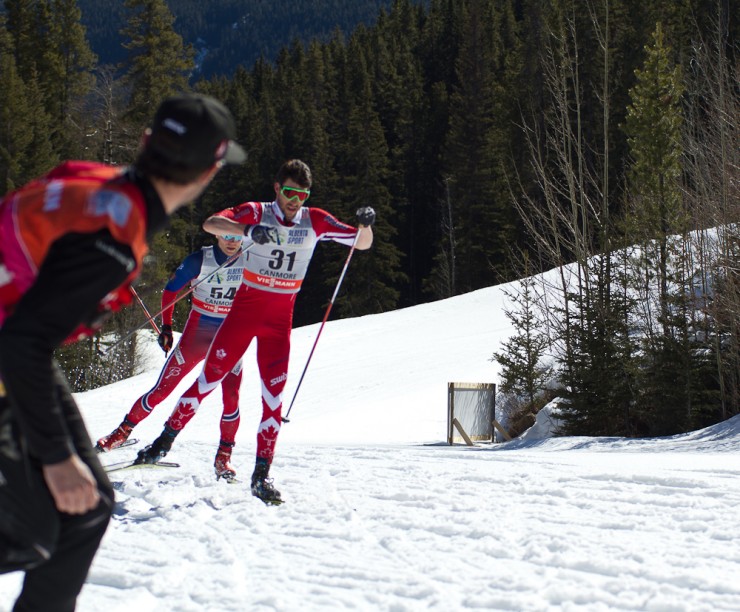 Canada's Alex Harvey leads Erik Brandsdal of Norway while Canadian head coach Justin Wadsworth (l) calls out to him during the men's 15 k freestyle individual start on Friday at Stage 7 of the Ski Tour Canada in Canmore, Alberta. 
