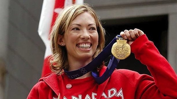 Beckie Scott with the gold medal she was awarded at a ceremony in Vancouver in June 2004. A former Canadian cross-country skier, Scott finished third in the 5 k pursuit at the 2002 Olympics but was later awarded gold when the two women ahead of her were disqualified for using performance-enhancing drugs. (Photo: Cross Country Canada)