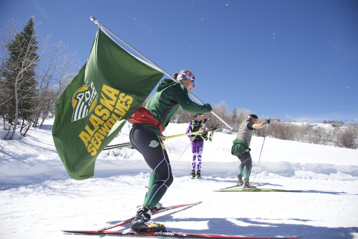 A University of Alaska Anchorage skier carries the team flag of the Seawolves at the 2016 NCAA Skiing Championships last March at Howelsen Hill in Steamboat Springs, Colo. (Photo: Jamie Schwaberow/NCAA Photos)