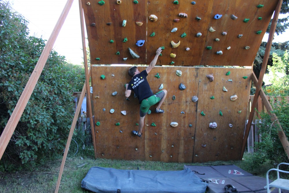 Jason Brendan demonstrating a left-hand lock-out on the backyard climbing wall in Bozeman, Mont. 