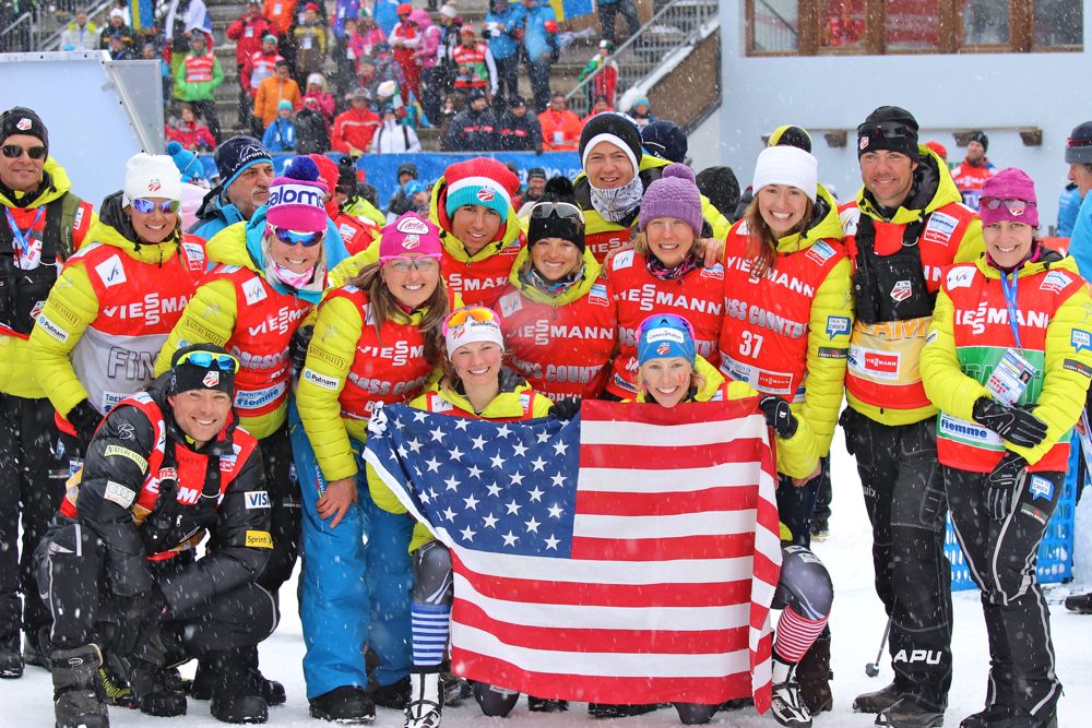 The 2013 U.S. World Championship team poses in Val di Fiemme, Italy, after Kikkan Randall and Jessie Diggins (front right, and left, with flag) won the women’s freestyle team sprint.