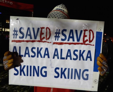 A supporter holds an updated sign at the #savealaskaskiing rally in Anchorage, Alaska, on Nov. 10, 2016. (Photo: Gavin Kentch)