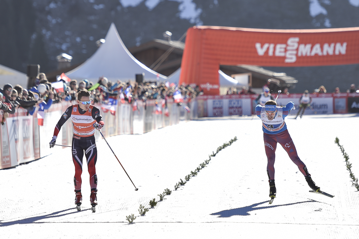 Finn Hågen Krogh (l) crossing the line ahead of Russia's Sergey Ustiugov to give Norway the win in the men's 4 x 8 k relay, the first of the World Cup season, in La Clusaz, France. (Photo: Fischer/NordicFocus)