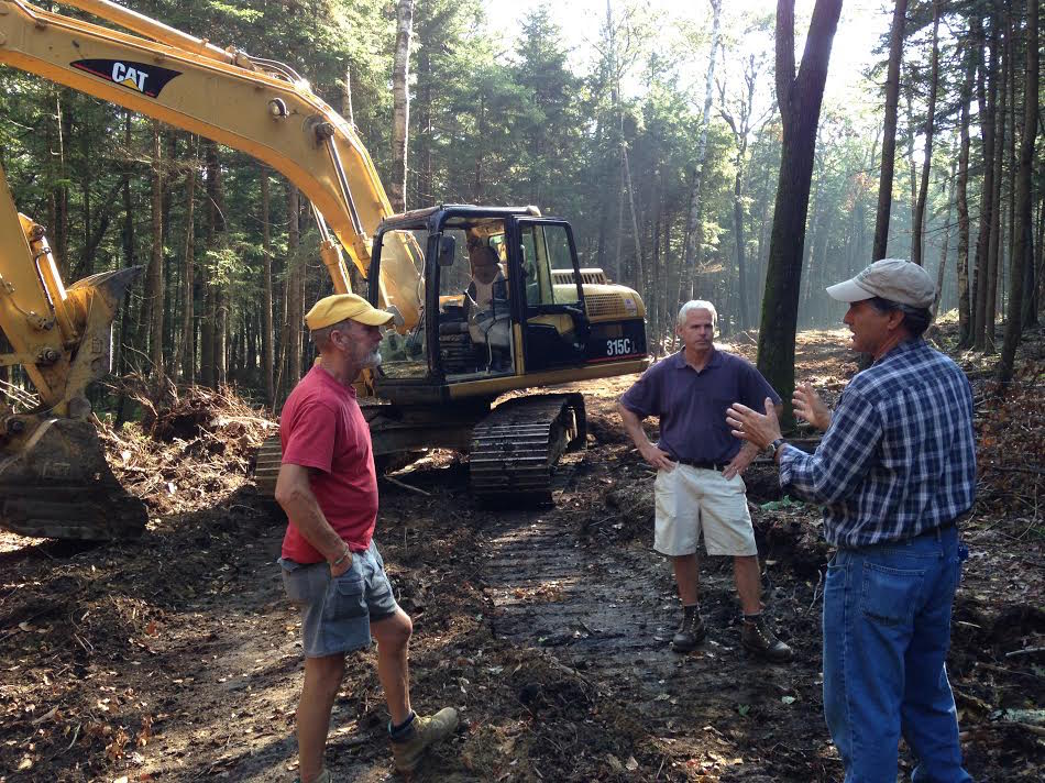 Owning their own excavator helped the Dublin School keep its construction costs down. (From left to right: excavator operator Bob Miles, project manager Andy Hungerford and trail designer John Morton. (Photo: Brad Bates/Dublin School)