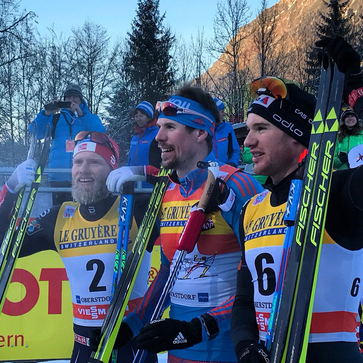 The men's 20 k skiathlon podium at Stage 3 of the Tour de Ski in Oberstdorf, Germany, with Russian winner Sergey Ustiugov (c), Norway's runner-up Martin Johnsrud Sundby (l), and Switzerland's Dario Cologna (r) in third. (Photo: FIS Cross Country/Twitter)