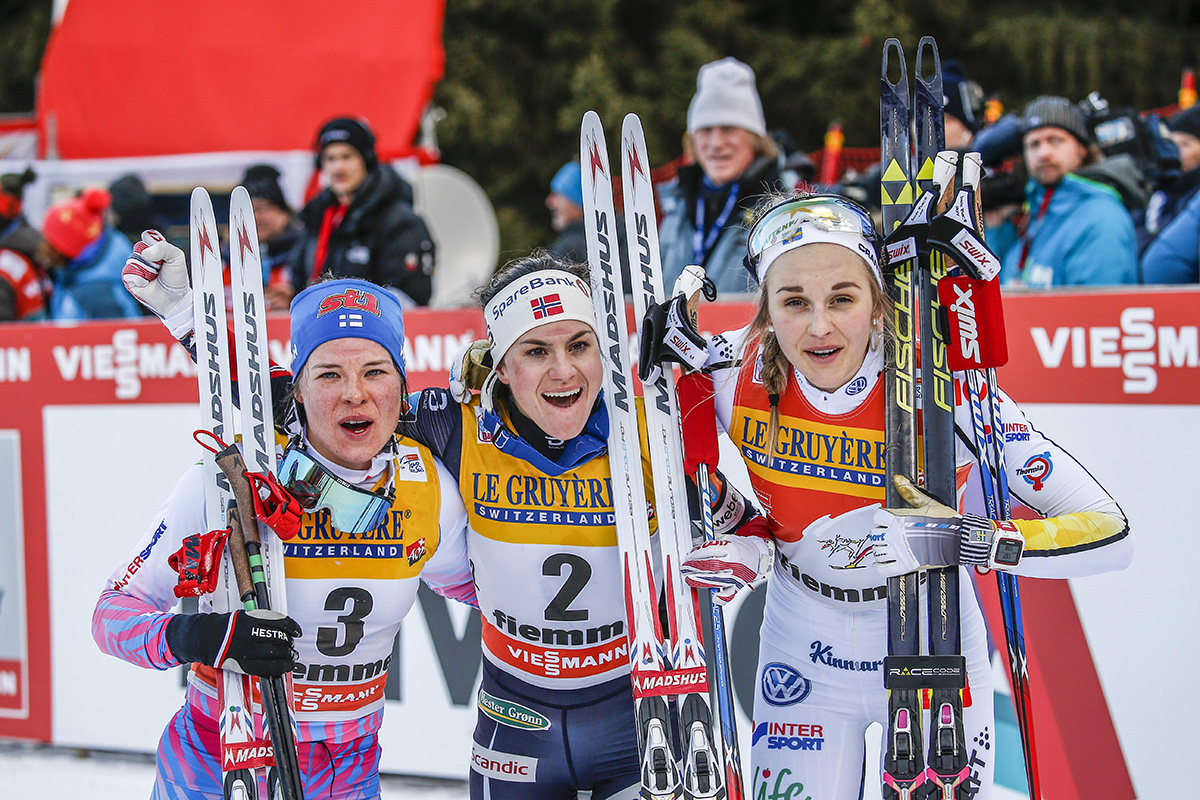 The 2017 Tour de Ski women's podium, as determined by the final climb on Sunday in Val di Fiemme, Italy, with winner Heidi Weng (c) of Norway, Finland's Krista Parmakoski (l) in second, Stina Nilsson (r) in third. (Photo: Fischer/NordicFocus)