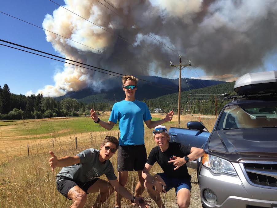 Fran Vukonic, Tallon Noble, and Ian Williams pose at the end of a bluebird day trail run at Big White in front of the newest Kelowna fire, September 5, 2017. (Photo: Gareth Williams)