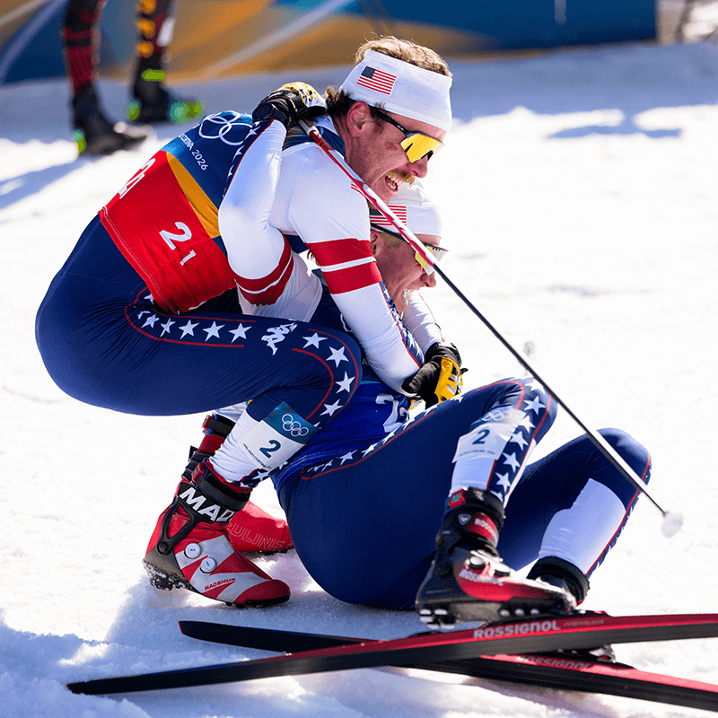 Ben Ogden and Gus Schumacher embracing at the finish of the Olympic team sprint