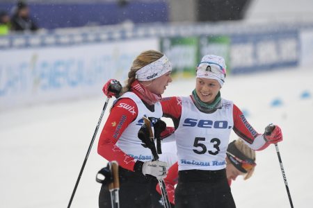Team spirit. Hannah Mehain (bib 53) hugs Natalie Hynes while Sadie White takes her skis off in the background. (Photo: Doug Stephen)
